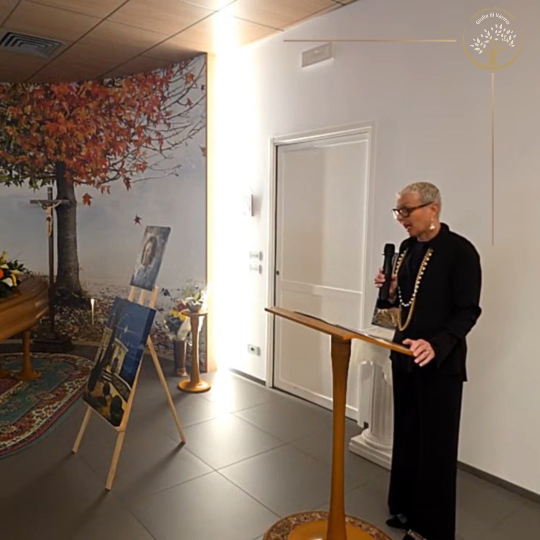 Fotografia, fiori e leggio allestiti per una cerimonia di commiato a Udine